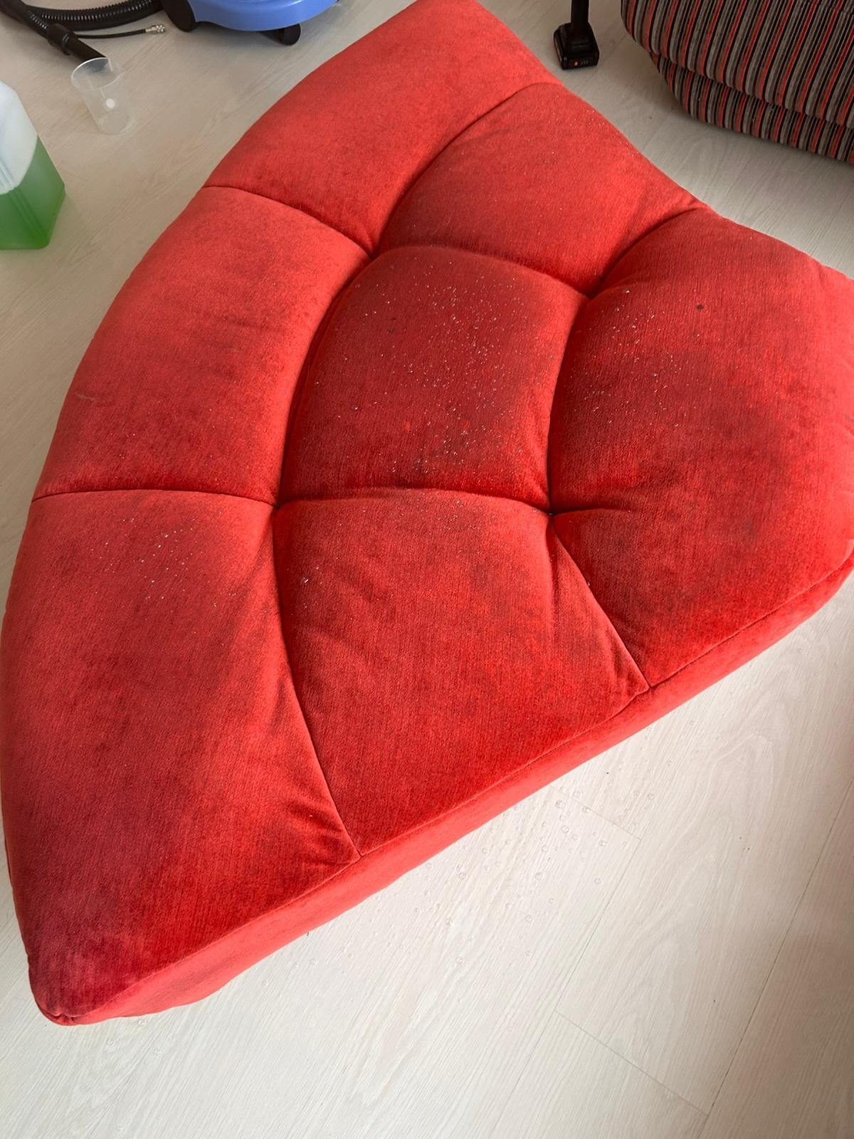 Canapé rouge capitonné avant le nettoyage