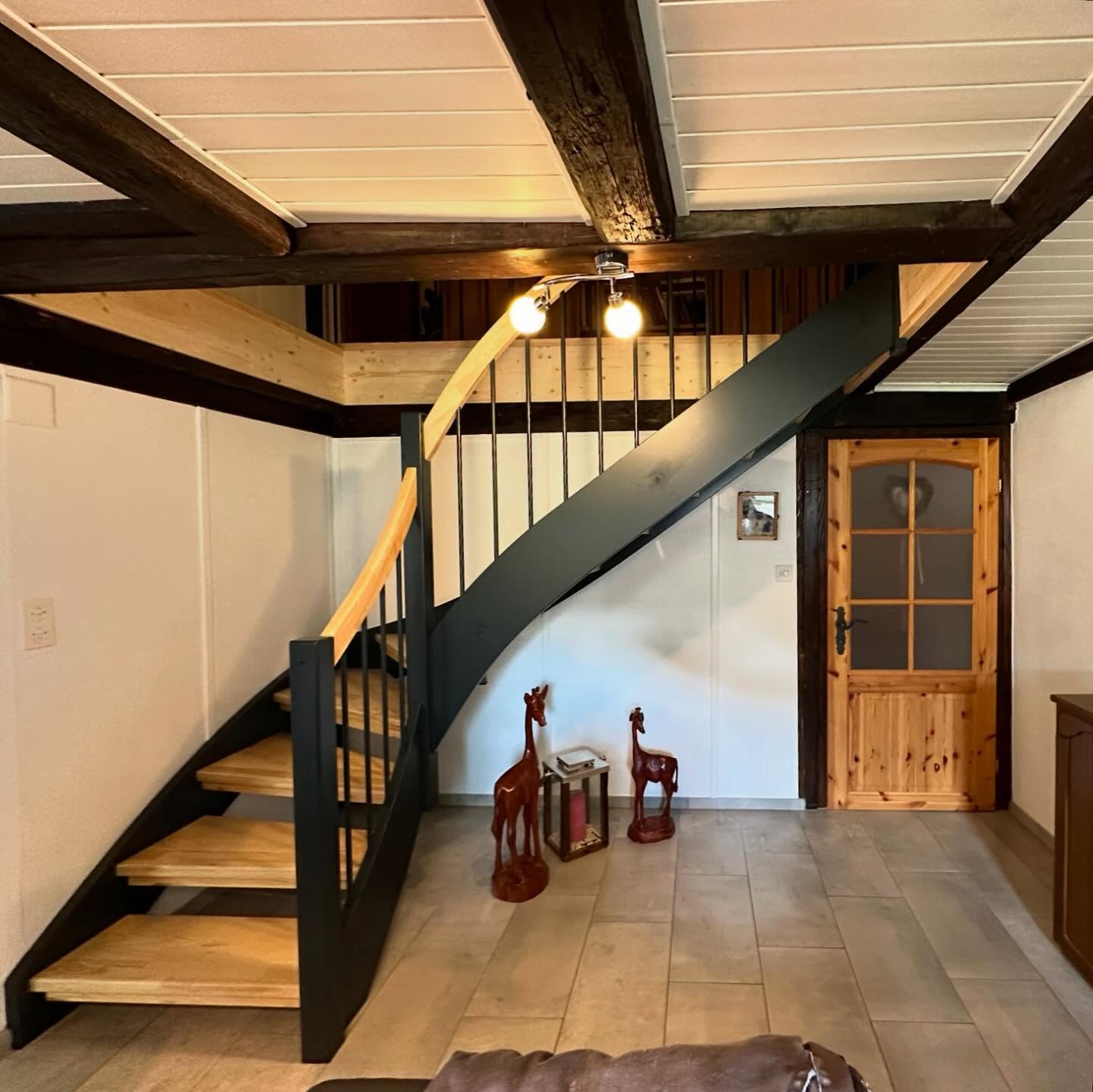 Escalier en bois et structure anthracite intégré sous des poutres anciennes