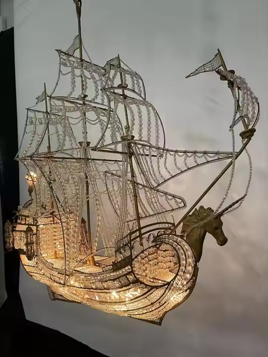 Illuminated sailing-ship chandelier with crystal-beaded sails, gold-toned framework, and a horse-head figurehead.