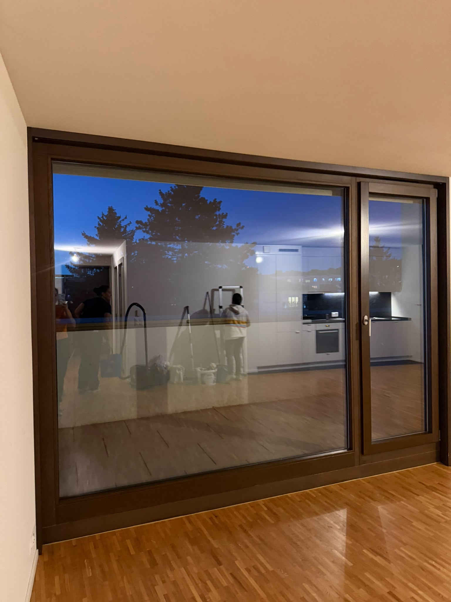Baie vitrée et parquet d’un appartement en cours de nettoyage